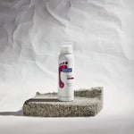 Footlogix Rough Skin Formula productfoto op een achtergrond met ruwe huidstructuur voor de behandeling van eelt en schilferige voeten.